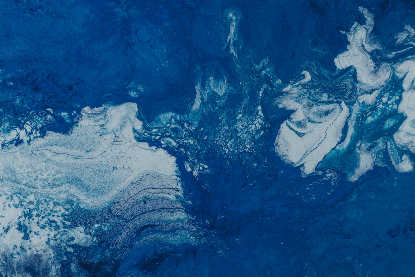 Pintura acrílica azul y blanca arremolinada en patrones oceánicos.